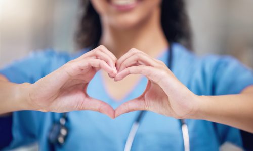 Happy woman, doctor and heart shape hands for love in healthcare or life insurance at the hospital. Female person or medical professional showing hand loving emoji, symbol or sign gesture at clinic.